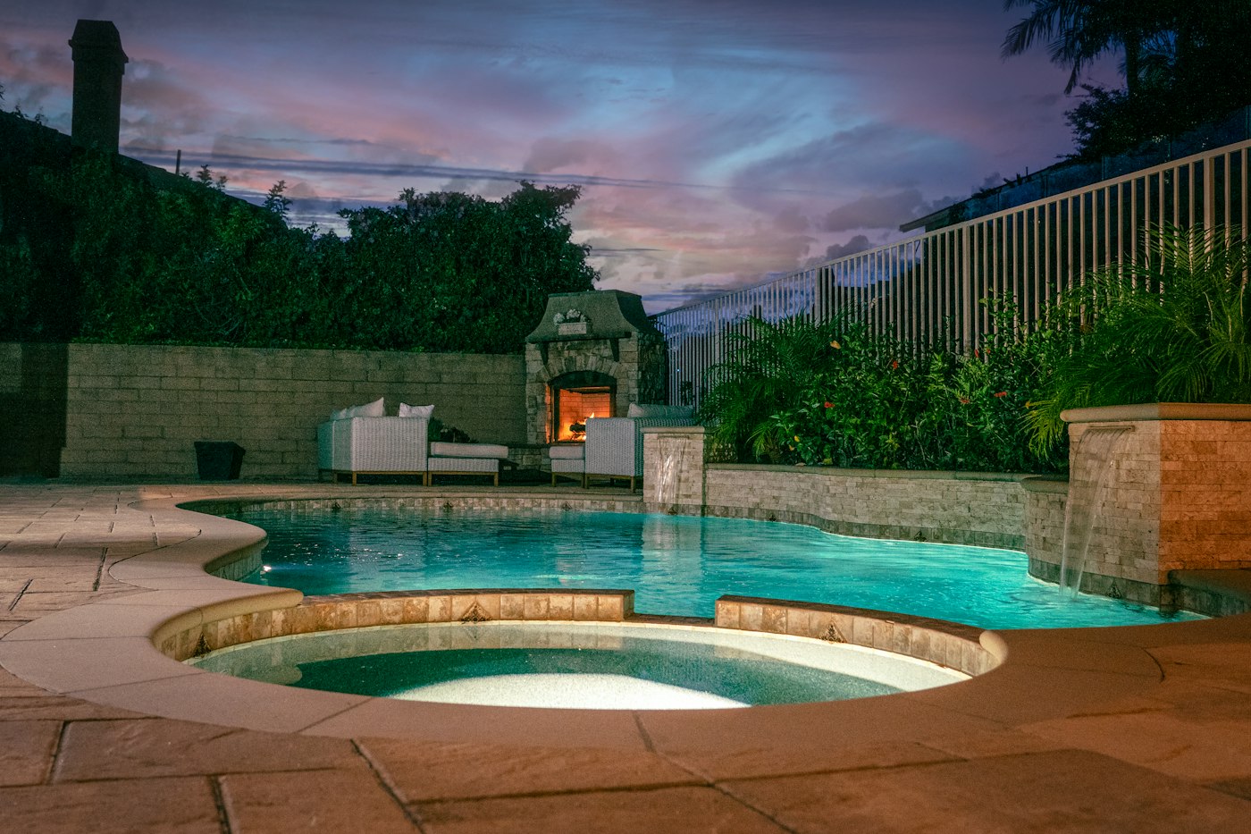 Freeform pool and spa lit at dusk