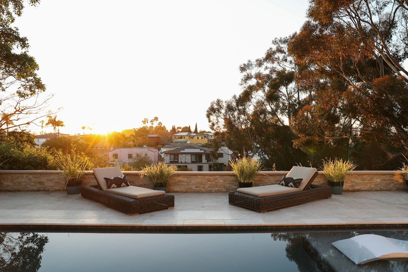 Infinity-edge pool with lounge chairs at sunset