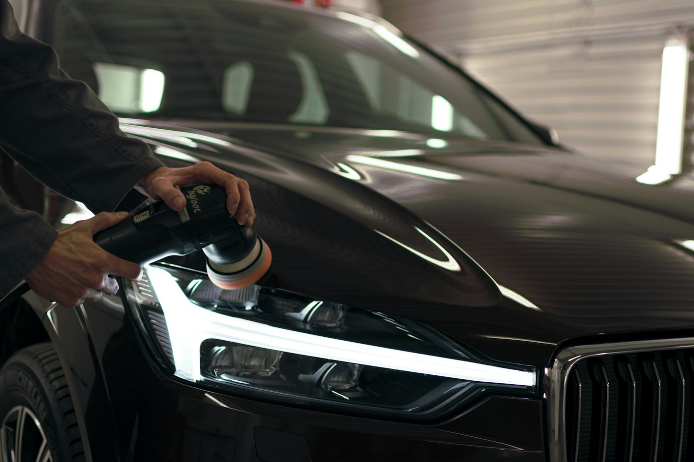Machine polishing the hood of a black car