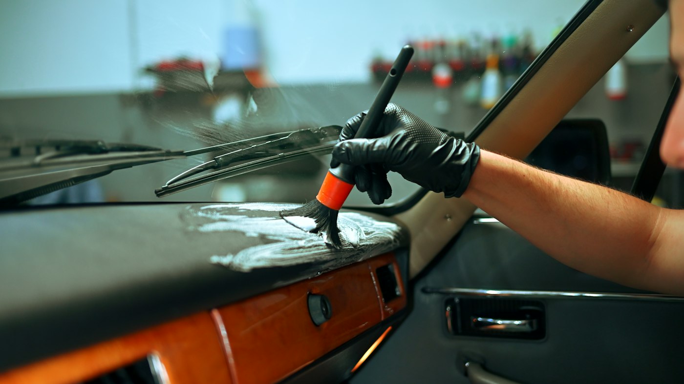 Detail brush cleaning a car interior